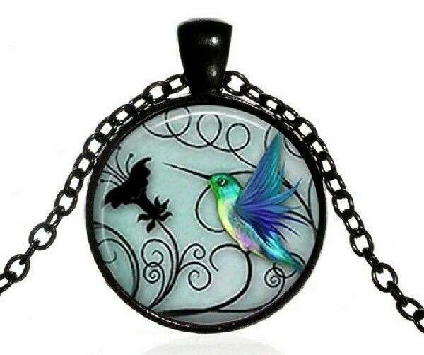 A Round capsule with Art of a Hummingbird with background in Black and Blue - $16.78
