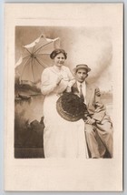 RPPC Lovely Couple Faux Beach Scene Woman Fringe Umbrella Hat Studio Postcard I2 - £13.33 GBP