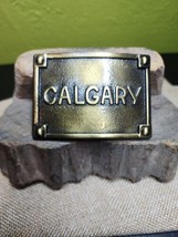 Calgary Belt Buckle Embossed Brass Tone Metal Buckle Canadian Cowboy 1970s - $24.74