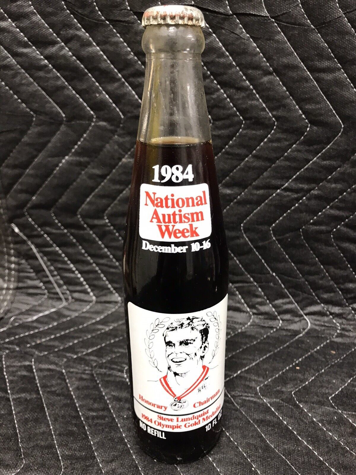 Primary image for 1984 COCA COLA Unopened BOTTLE NATIONAL AUTISM WEEK STEVE LUNDQUIST OLYMPIC GOLD