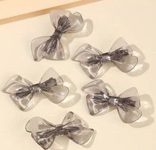 Gray acrylic bow hair clips - $225.18 MXN
