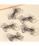 Gray acrylic bow hair clips - $223.49 MXN