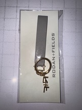 Rodan and Fields gray leatherette &amp; gold metal signature R&amp;F charm key c... - $129.41 MXN