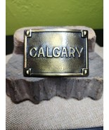 Calgary Belt Buckle Embossed Brass Tone Metal Buckle Canadian Cowboy 1970s - $22.28