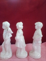 3 white porcelain figurines..2 boys and a girl - $55.98