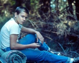 River Phoenix in t-shirt &amp; jeans seated in woods stand By Me 8x10 inch photo - £7.69 GBP