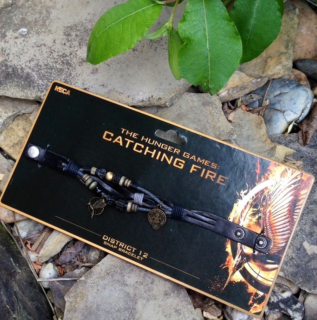 Primary image for The Hunger Games Catching Fire District 12 Snap Bracelet with Charms by NECA