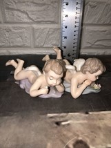 2 Vtg Porcelain Cherubs Angel Laying Foot Up  Figurines Hand Painted In China - £34.41 GBP