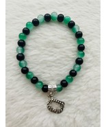 Green and black glass bead bracelet with mister teeth charm. - $7.00
