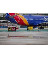 Airliner taxiing and runway/taxiway signs - HD digital photograph download. - $111.84 MXN