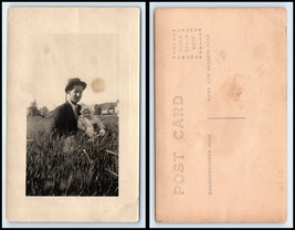 RPPC PHOTO Postcard - Man Standing In Tall Grass Holding Baby C28 - £3.13 GBP