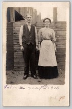RPPC Woman In Apron And Man Pose In Dirt Yard Wood Fence Postcard M25 - £5.55 GBP