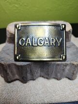 Calgary Belt Buckle Embossed Brass Tone Metal Buckle Canadian Cowboy 1970s - $23.86