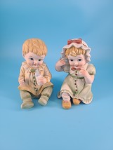 VINTAGE PAIR 7.5&quot; BISQUE SITTING DOWN PIANO BABIES Flambro Porcelain Green - $15.85