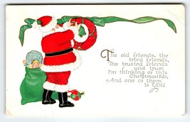 Santa Claus Christmas Postcard Saint Nick Hangs Wreath Decorations Toys 1930 - £7.43 GBP