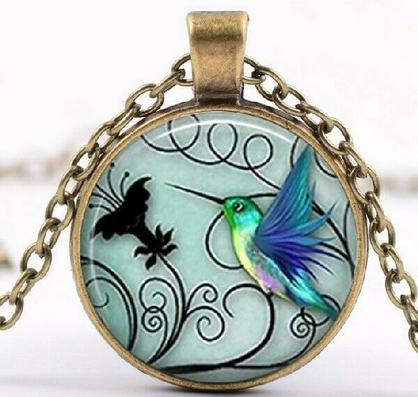 A Round capsule with Art of a Hummingbird with background in Silver - $17.77