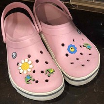 Classic pink Crocs with various shoe charms dinosaurs daisies women’s si... - $50.49