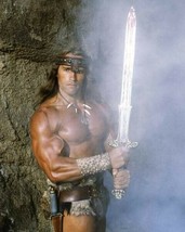 Arnold Schwarzenegger holds the gleaming sword as Conan The Barbarian 8x10 photo - £7.62 GBP
