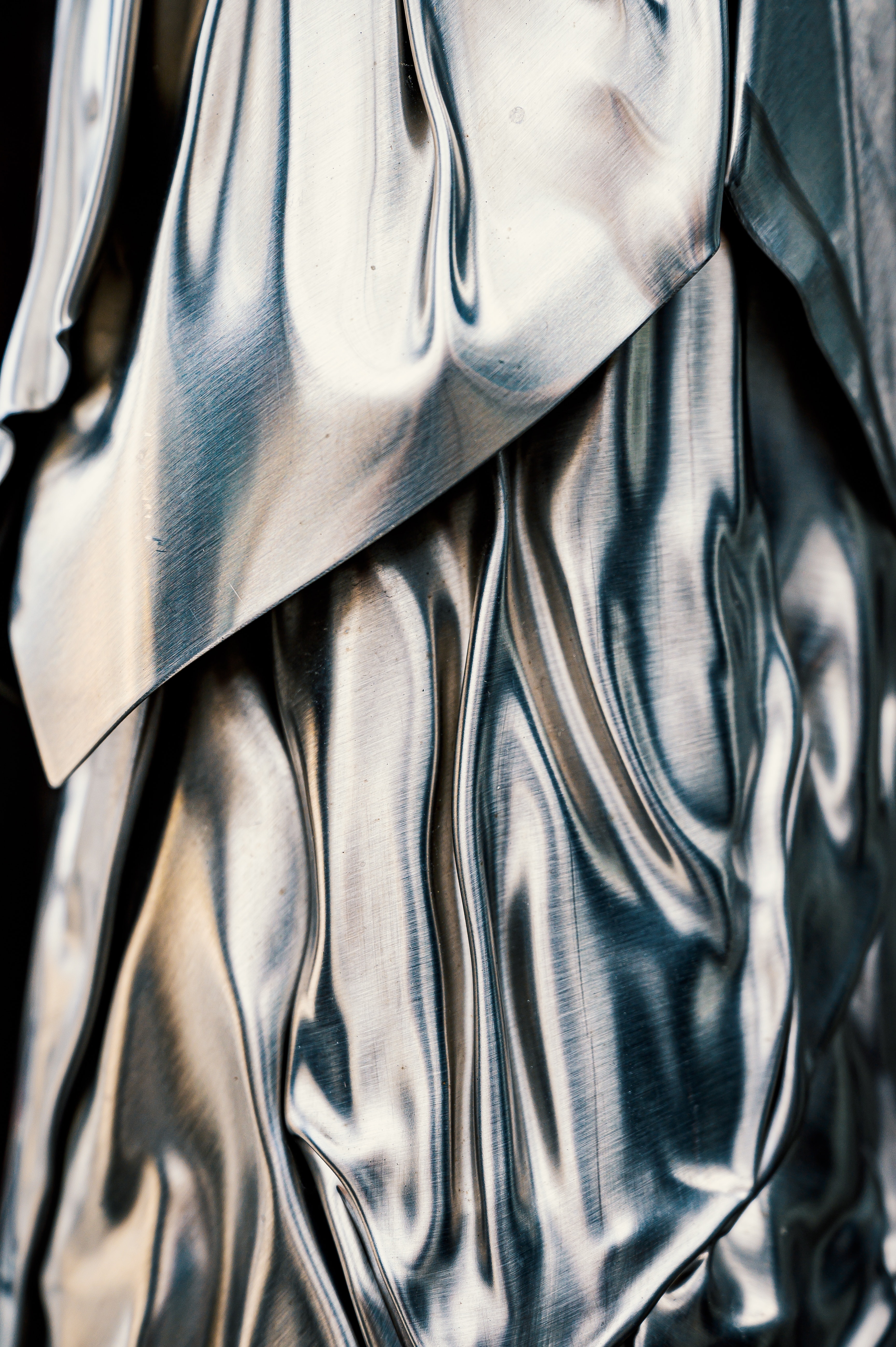 Shiny silver metalic fabric flows luxuriously over itself