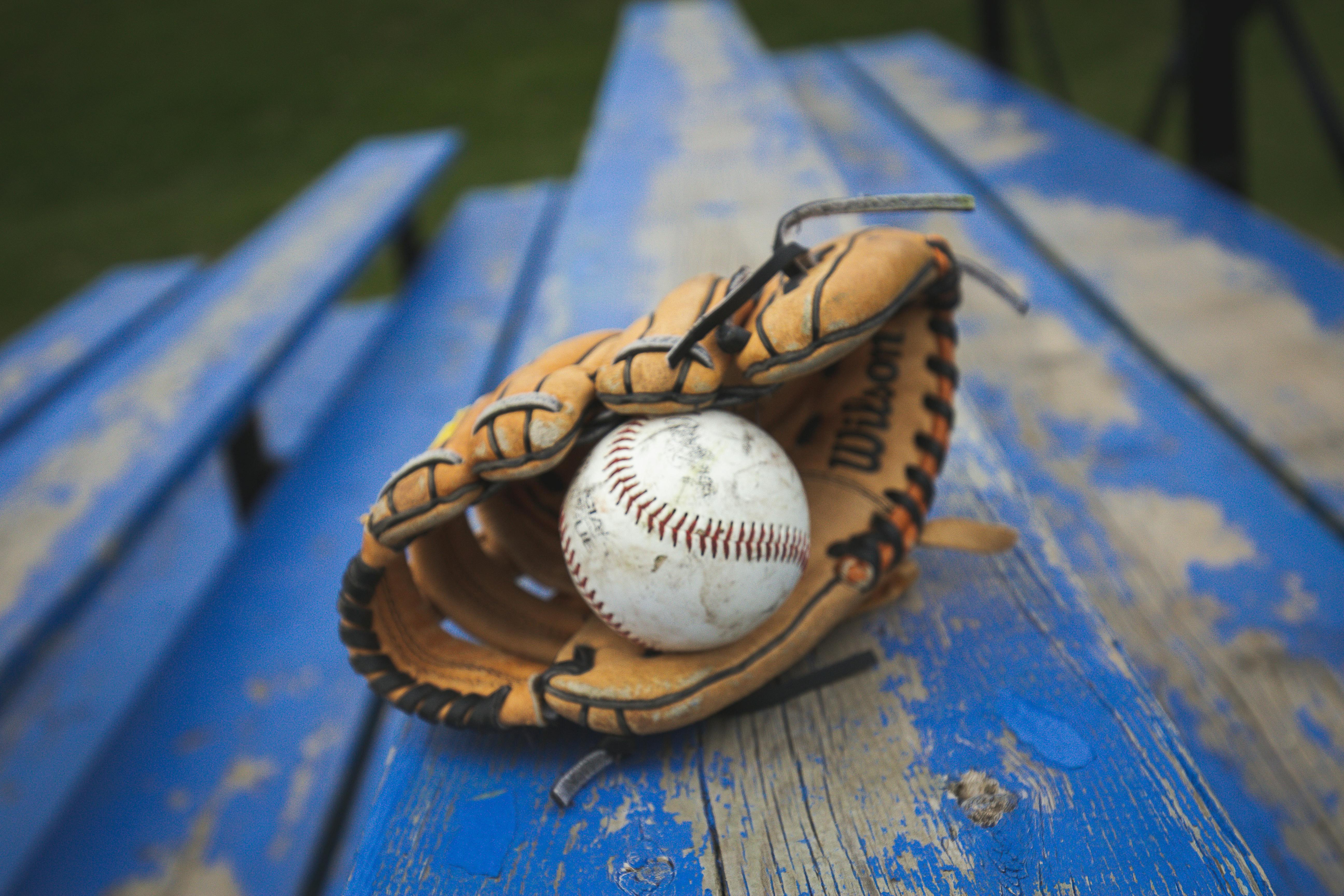 image of baseball mit and baseball on blue bleachers